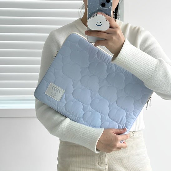 Femme tenant housse pour ordinateur matelassée bleu clair